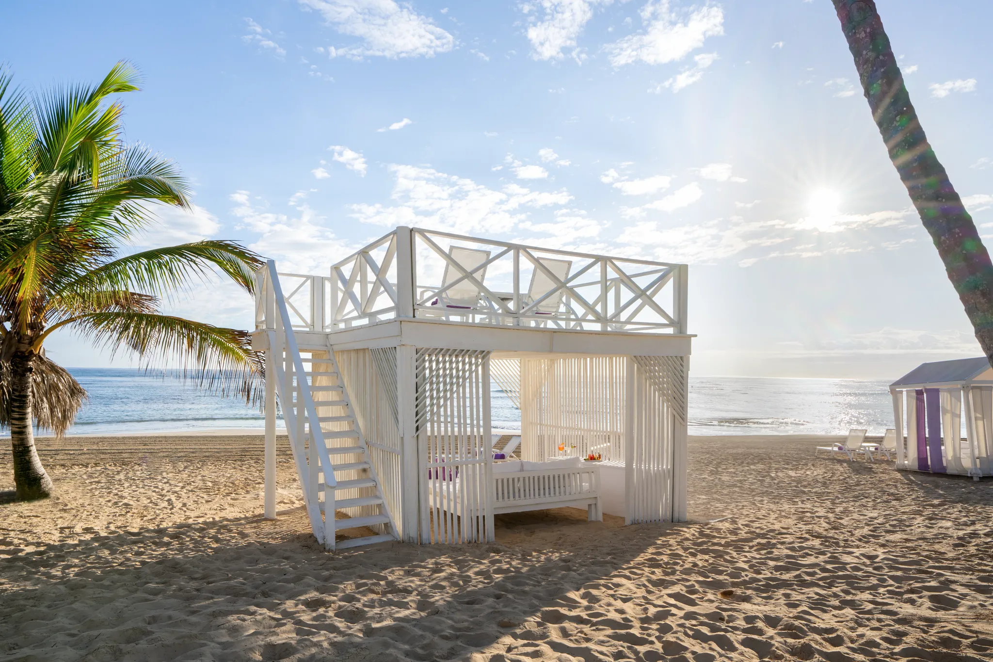 Beachfront cabanas and palm trees forming a tranquil beach oasis at Breathless Punta Cana.