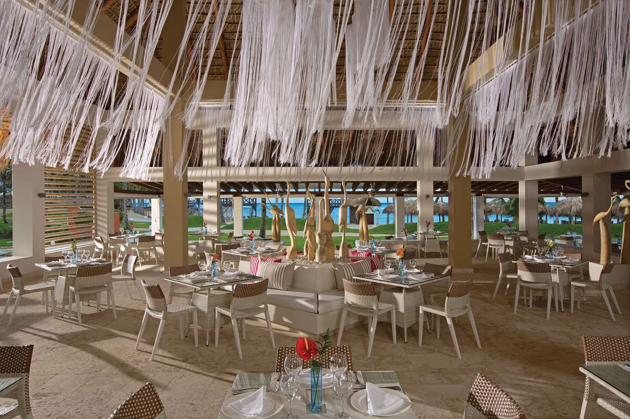 The Strip Grill steakhouse at Breathless Punta Cana featuring open-air dining, elegant table settings, and oceanfront views of the Caribbean Sea.